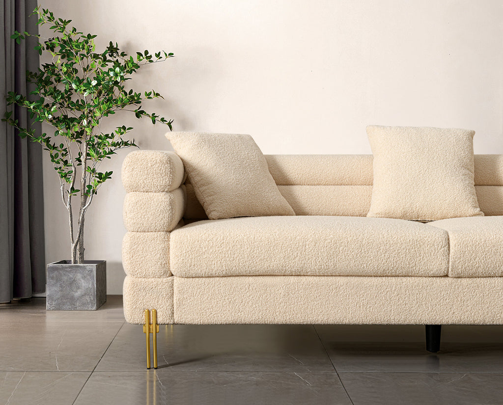 Luxurious and comfortable upholstered sofa with golden legs and pillows for living room and reception area