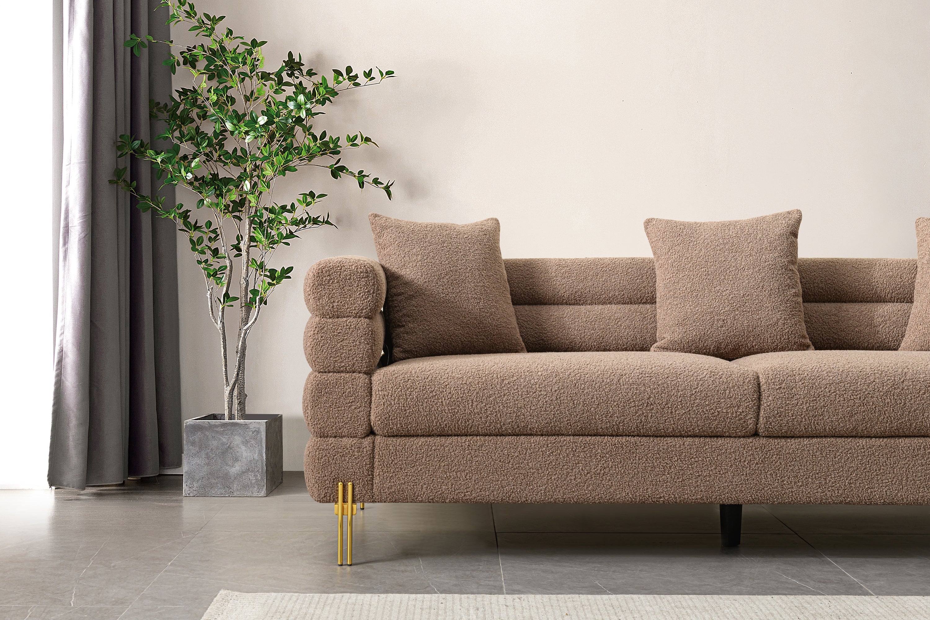 Luxurious and comfortable upholstered sofa with golden legs and pillows for living room and reception area