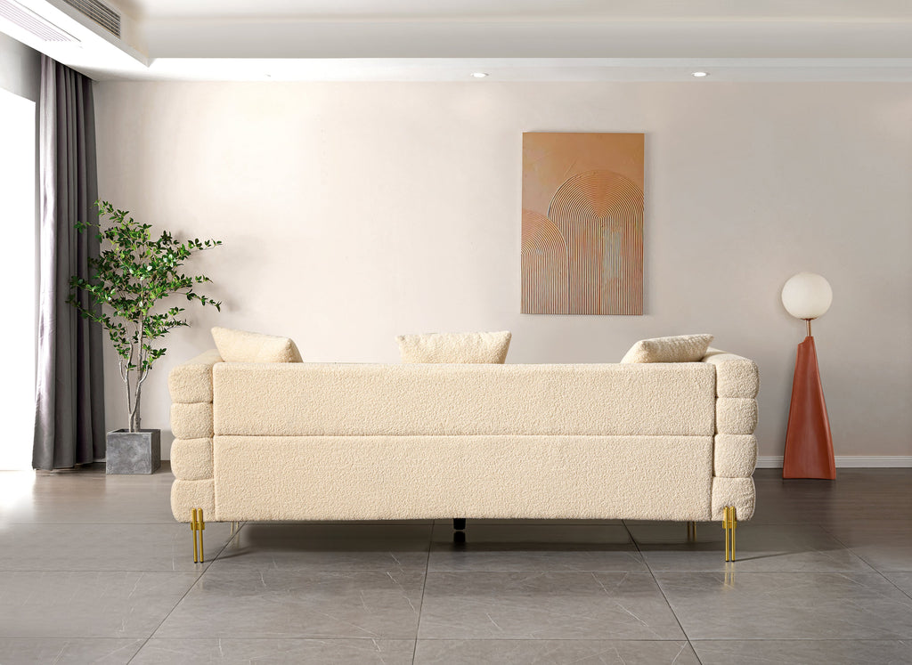 Luxurious and comfortable upholstered sofa with golden legs and pillows for living room and reception area